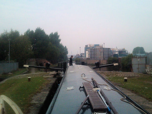 Narrowboat in lock in industrial setting